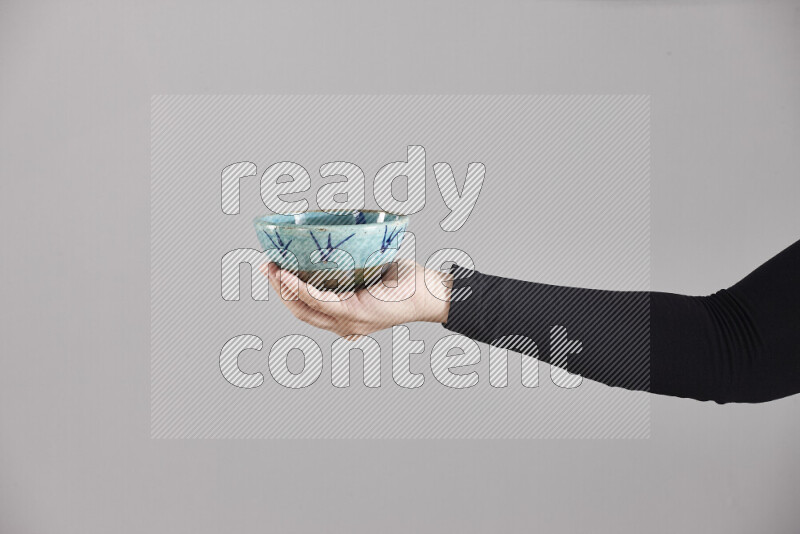 A woman in black abaya holding different pottery essentials in different positions