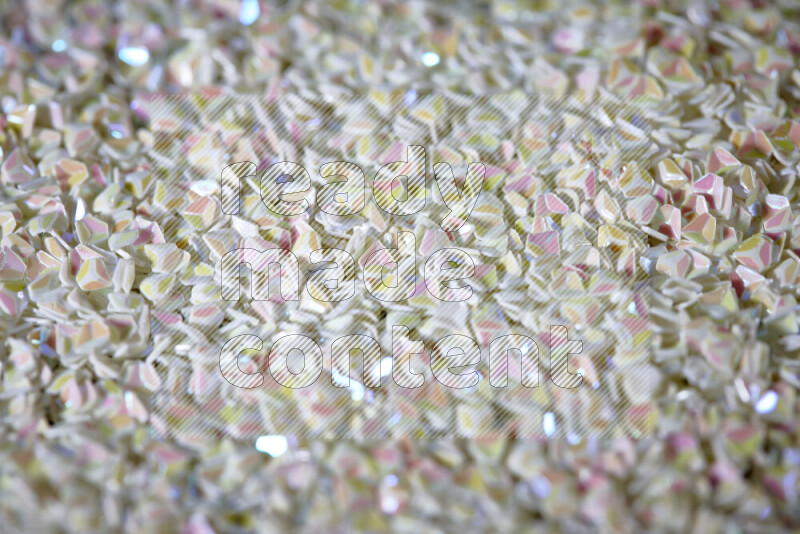 قطع صغيرة بلاستيكية ملونة للزينة متناثرة على خلفية سوداء