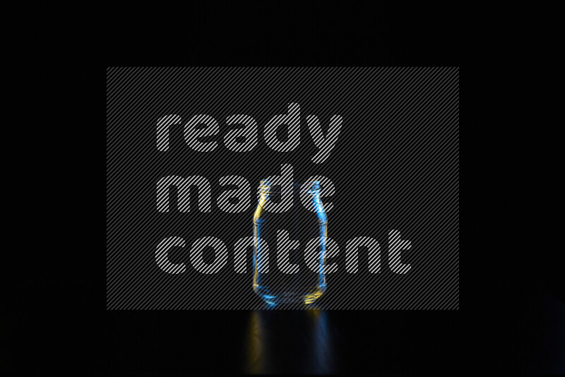 أواني زجاجية مع حواف مضيئة باللونين الأزرق والأصفر على خلفية سوداء