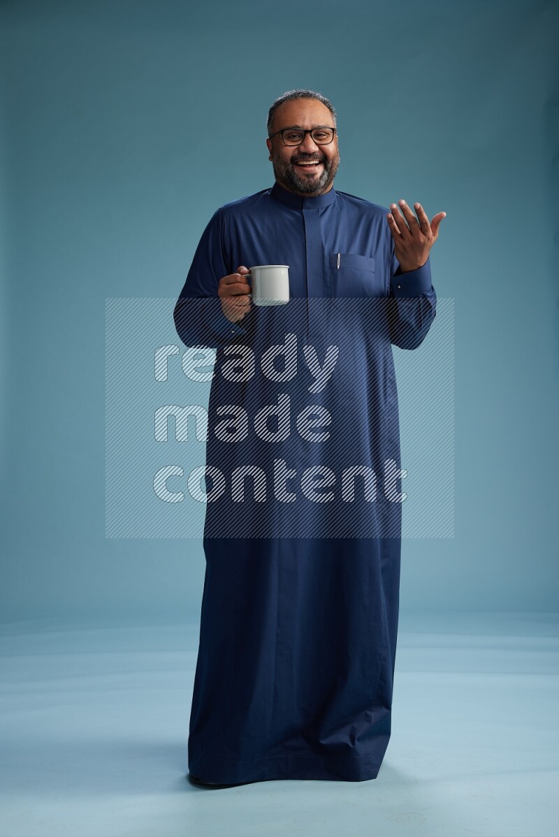 Saudi Man without shimag Standing drinking coffee on blue background