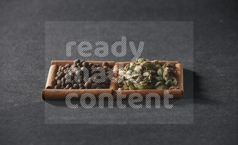 2 squares of cinnamon sticks full of allspice and cardamom on black flooring