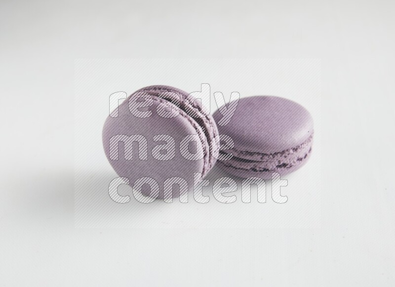 45º Shot of two Purple Blueberry macarons on white background