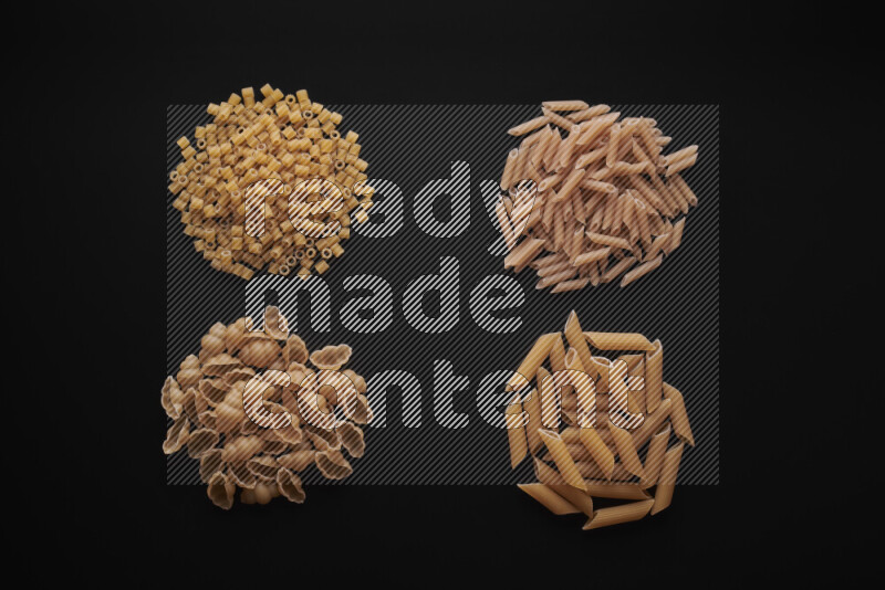 Different pasta types in bunches on black background