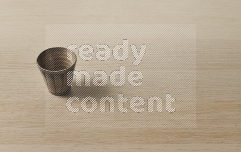 A pottery cup on light wooden background