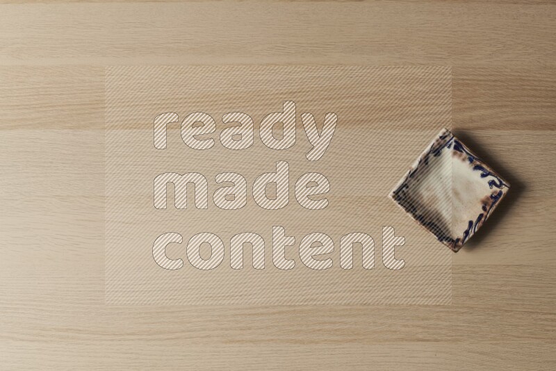 صحن فخاري مزخرف على خلفية خشبية فاتحة