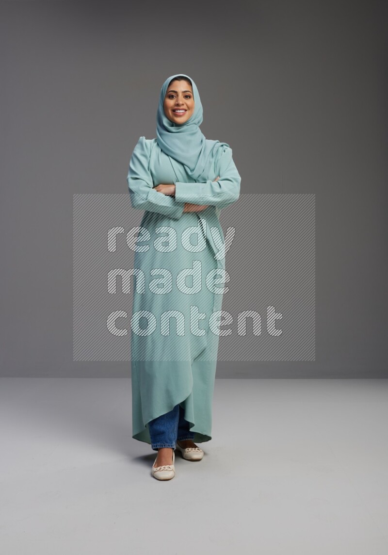 Saudi Woman wearing Abaya standing with crossed arms on Gray background
