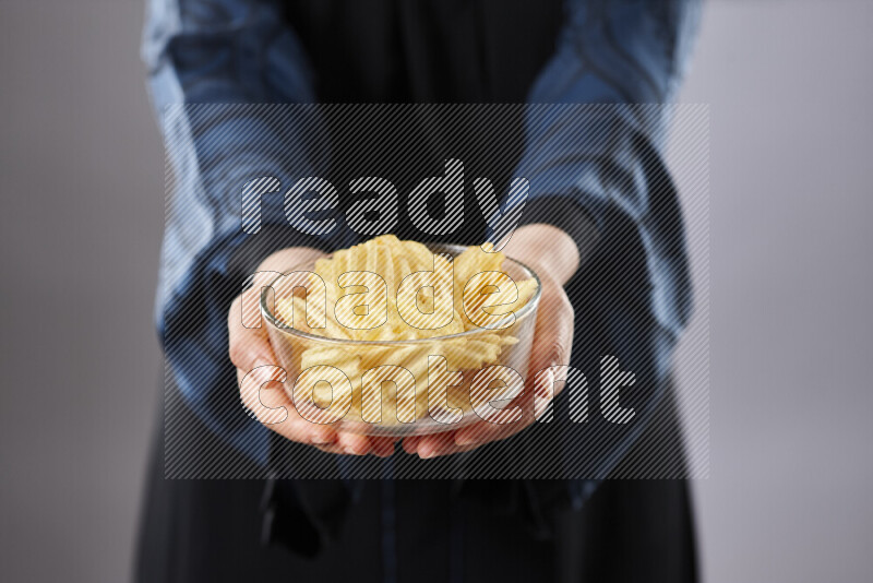 Woman in abaya holding different kinds of snacks in different positions