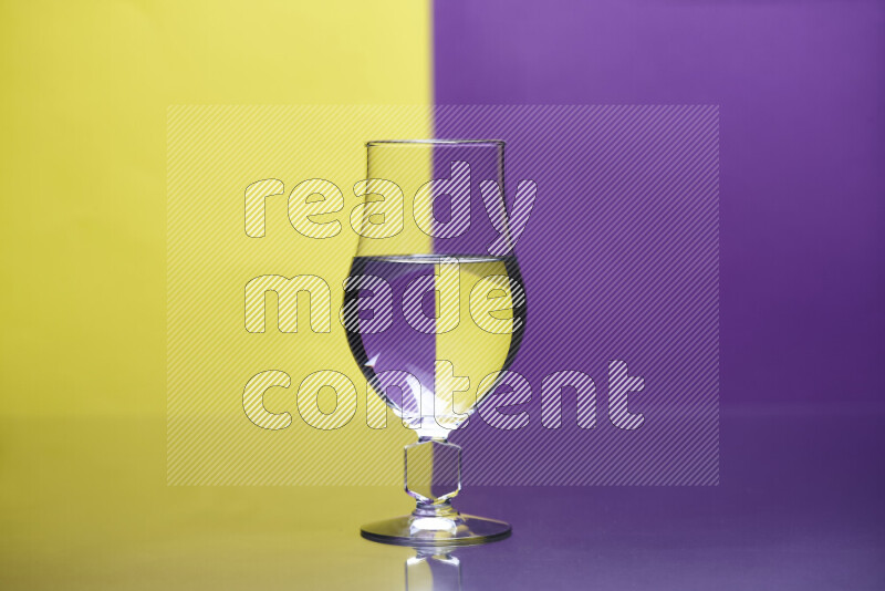 The image features a clear glassware filled with water, set against yellow and purple background