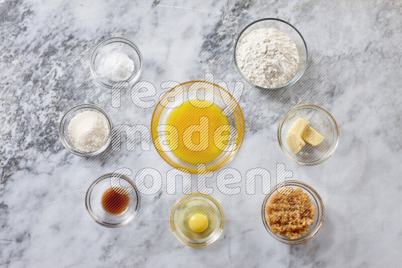 Cookies step by step with its ingredient, flour, butter, brown sugar, egg, vanilla extract, white sugar, chocolate chips and baking soda on grey marble background