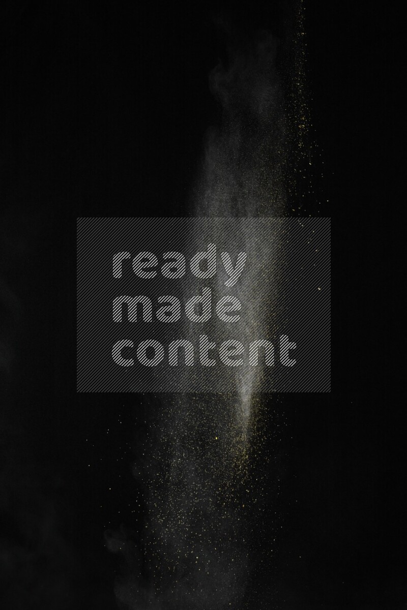 A side view of yellow powder explosion on black background