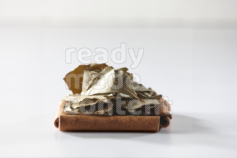 A single square of cinnamon sticks full of laurel bay on white flooring