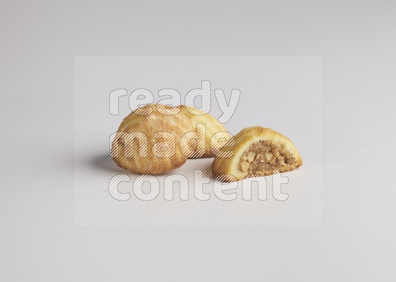 Three Pieces of Maamoul filled with walnut paste  one of them is cut direct on white background