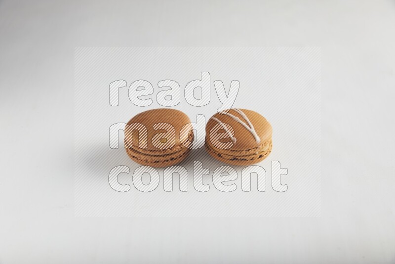 45º Shot of of two assorted Brown Irish Cream, and Brown Coffee macarons  on white background