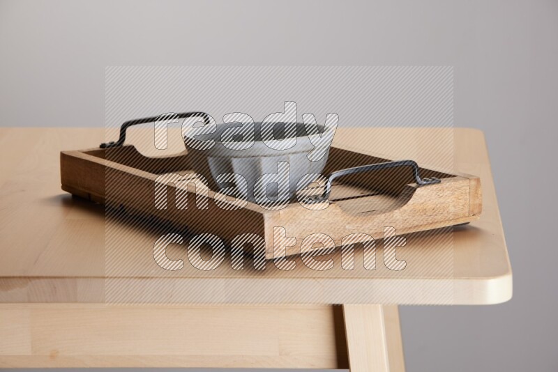 grey bowl on a light colored rectangular wooden tray with handles