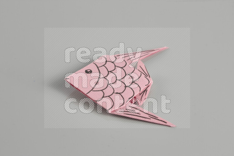 Origami fish on grey background