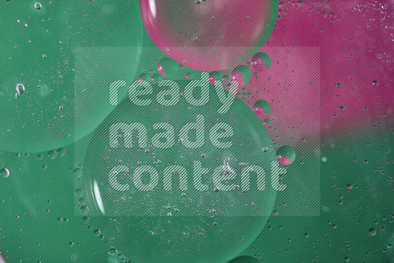 Close-ups of abstract oil bubbles on water surface in shades of green and pink