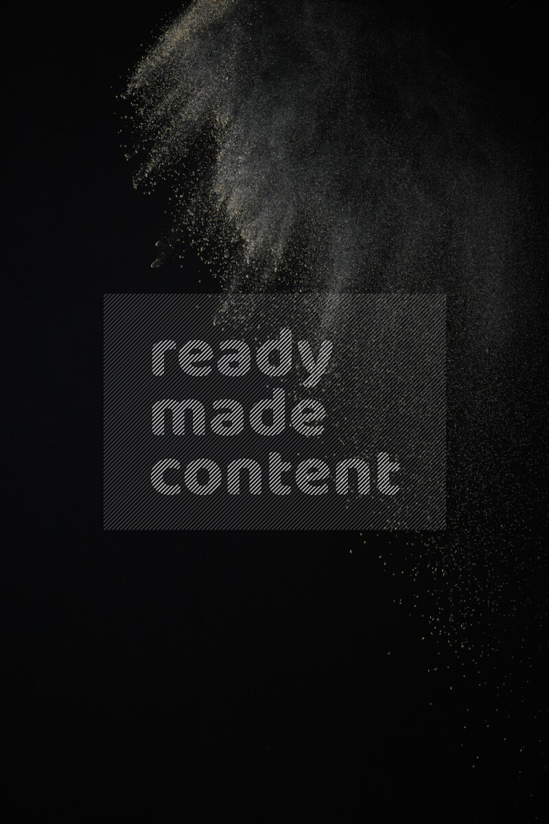 A side view of brown powder explosion on black background