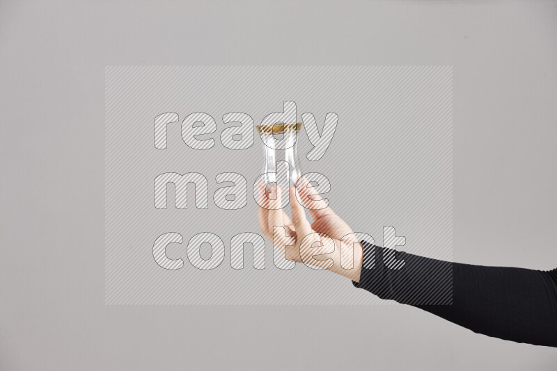 A woman in black abaya holding different glassware in different positions