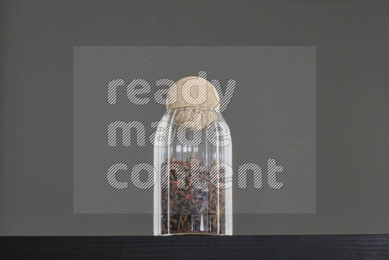 Star anise in a glass jar on black background