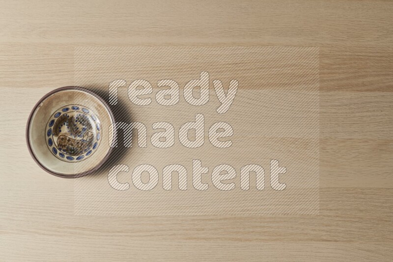 A decorative pottery plate on light wooden background