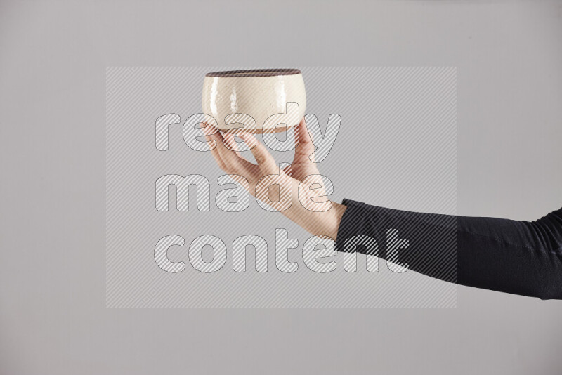 A woman in black abaya holding different pottery essentials in different positions