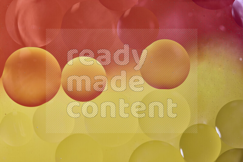 لقطات مقربة لفقاعات من الزيت على سطح الماء باللون الأحمر والأصفر