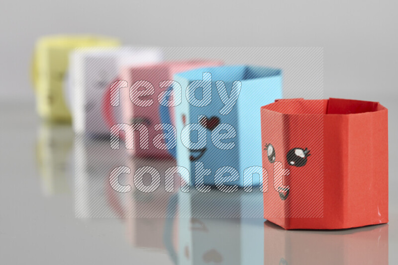 Origami cup on grey background