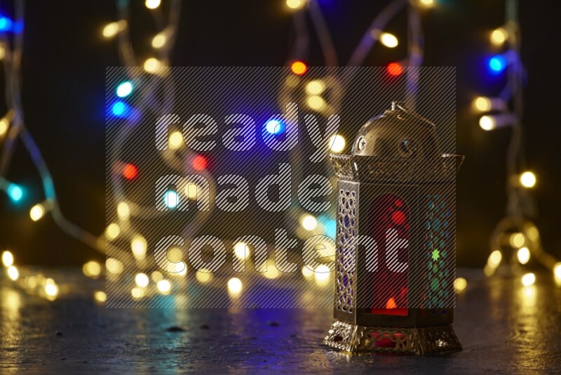 A traditional ramadan lantern surrounded by glowing fairy lights in a dark setup