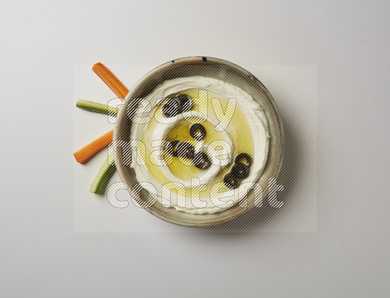 Lebnah garnished with sliced olives in a grey pottery plate on a white background
