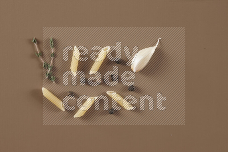 معكرونة مع مكونات متنوعة من الطماطم والثوم والبصل والفلفل الأحمر والفلفل الأسود والفلفل الأبيض وأوراق الغار وإكليل الجبل والهيل على خلفية بيج