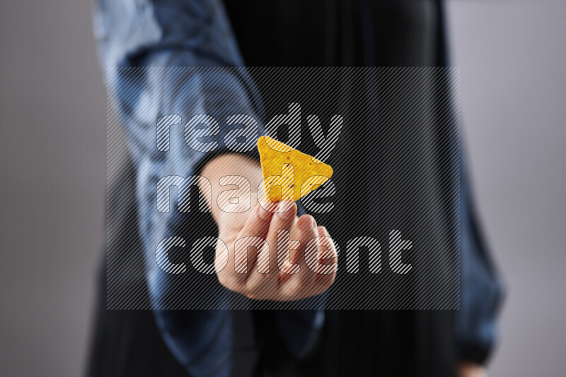 Woman in abaya holding different kinds of snacks in different positions