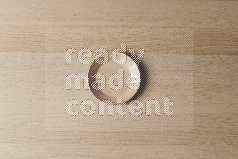 A beige pottery plate on light wooden background