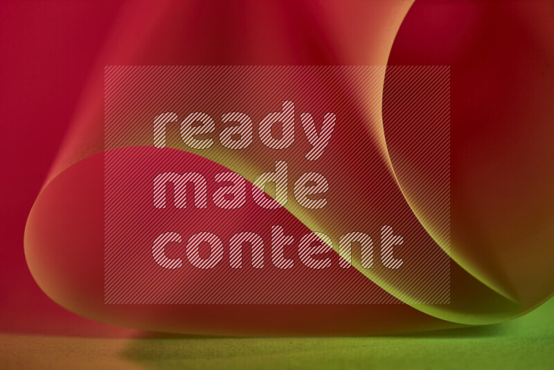 An abstract art piece displaying smooth curves in green and red gradients created by colored light