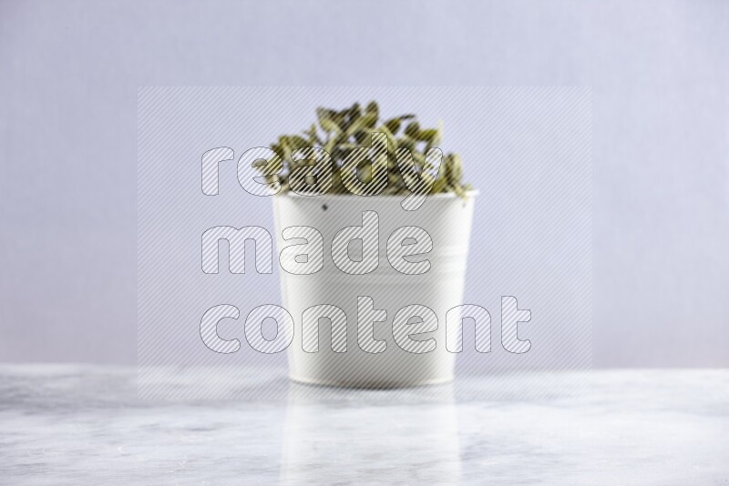 Artificial plant in white pot on grey marble background