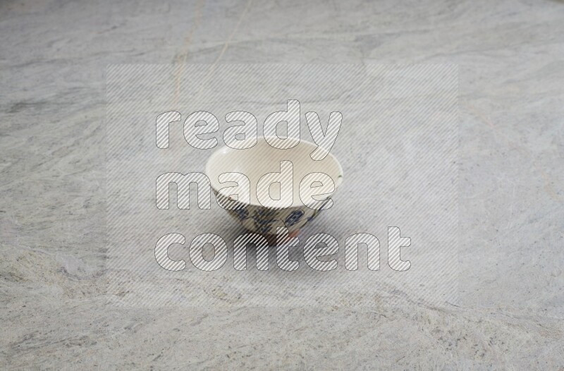 A multicolored pottery bowl on grey marble background