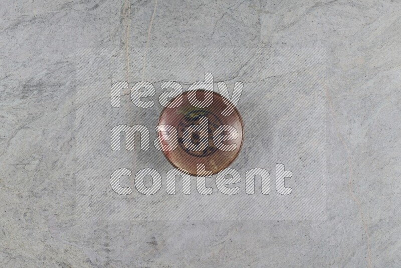A decorative pottery plate on grey marble background