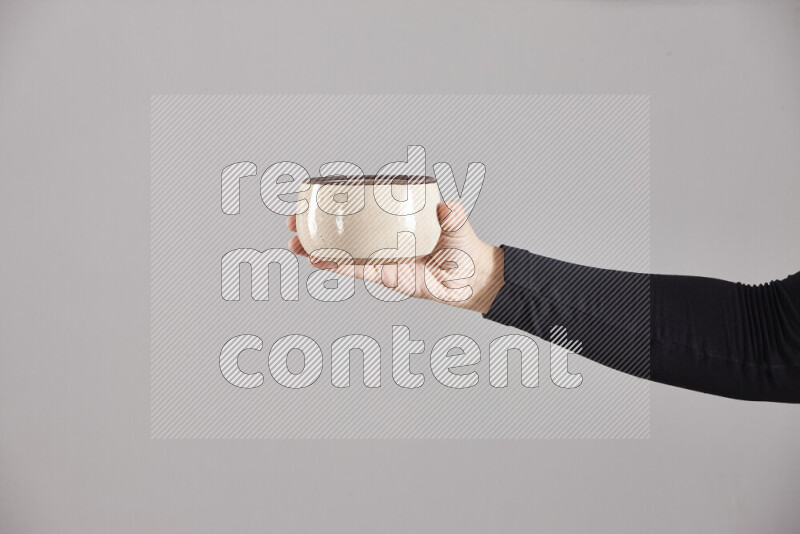 A woman in black abaya holding different pottery essentials in different positions
