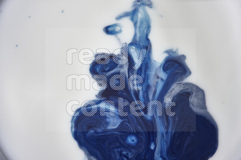 A close-up of sparkling gold glitter scattered on swirling blue background