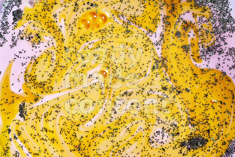 لقطة مقربة لبريق أخضر متلألئ منتشر على خلفية من اللون الأصفر والوردي في حركات دائرية