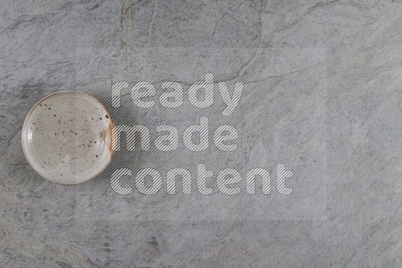 A multicolored pottery plate on grey marble background