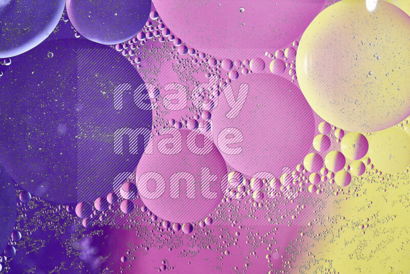 Close-ups of abstract oil bubbles on water surface in shades of yellow, purple and pink