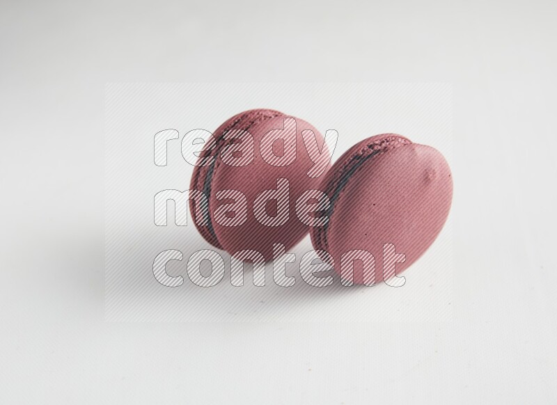 45º Shot of two Red Cherry macarons on white background