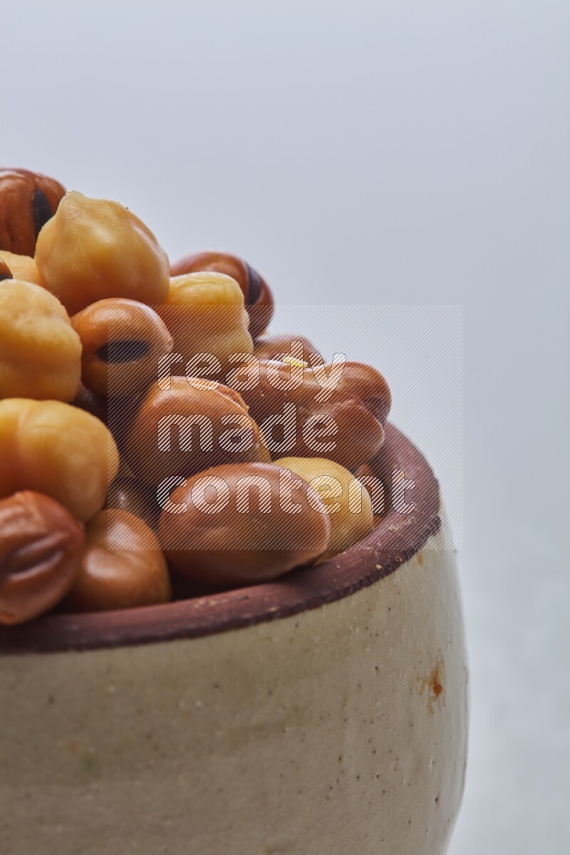 Close up shot of cooked fava beans (foul) & chickpeas on white background