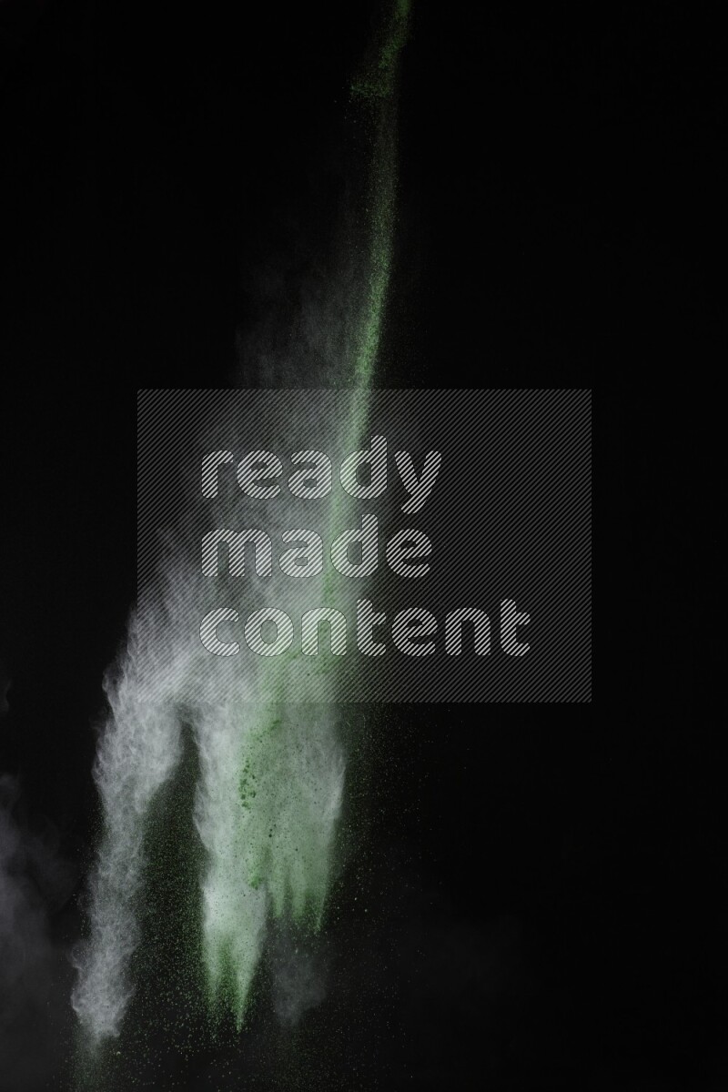 A side view of green powder explosion on black background