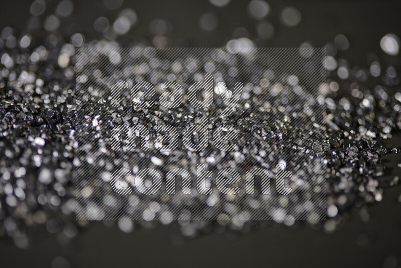 Black shimmering fragments of glass scattered on a black background