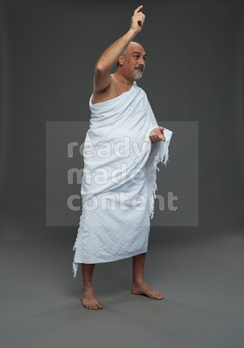 A man wearing Ehram Standing Interacting with the camera on gray background