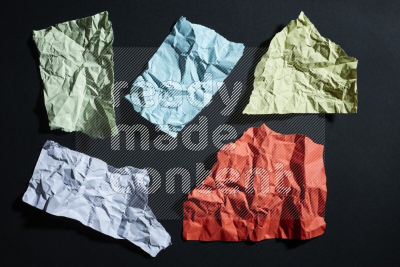 Crumpled multicolored paper on black background