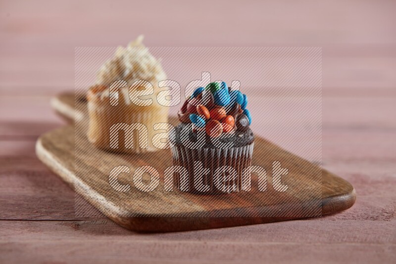 Chocolate mini cupcake topped with m&ms on a wooden board