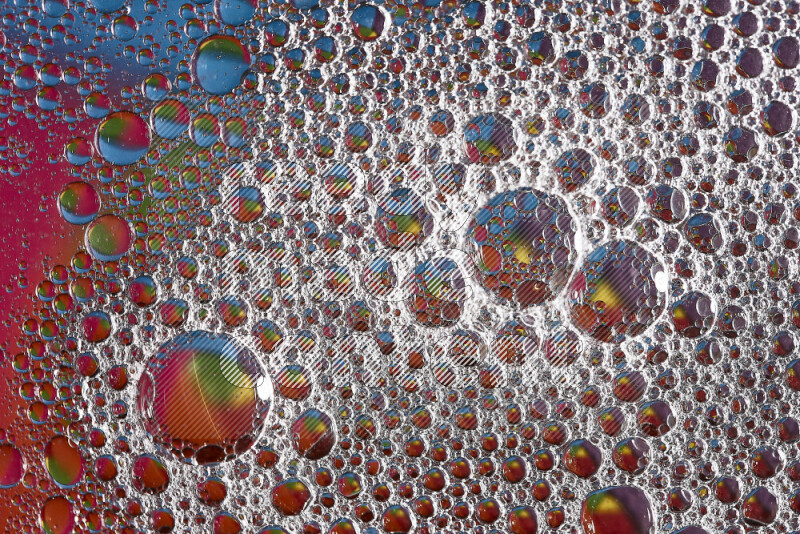 Close-ups of abstract soap bubbles and water droplets on multicolored background