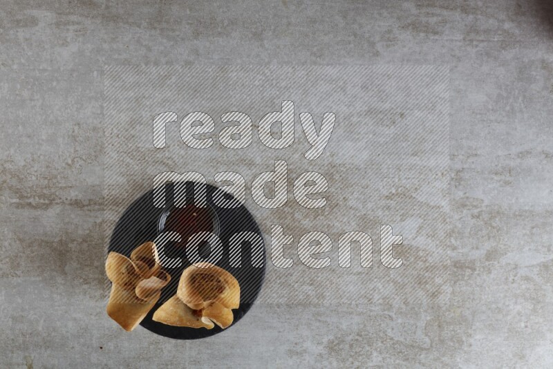 wonton cups with soy sauce ramkin on circle slate on grey textured counter top
